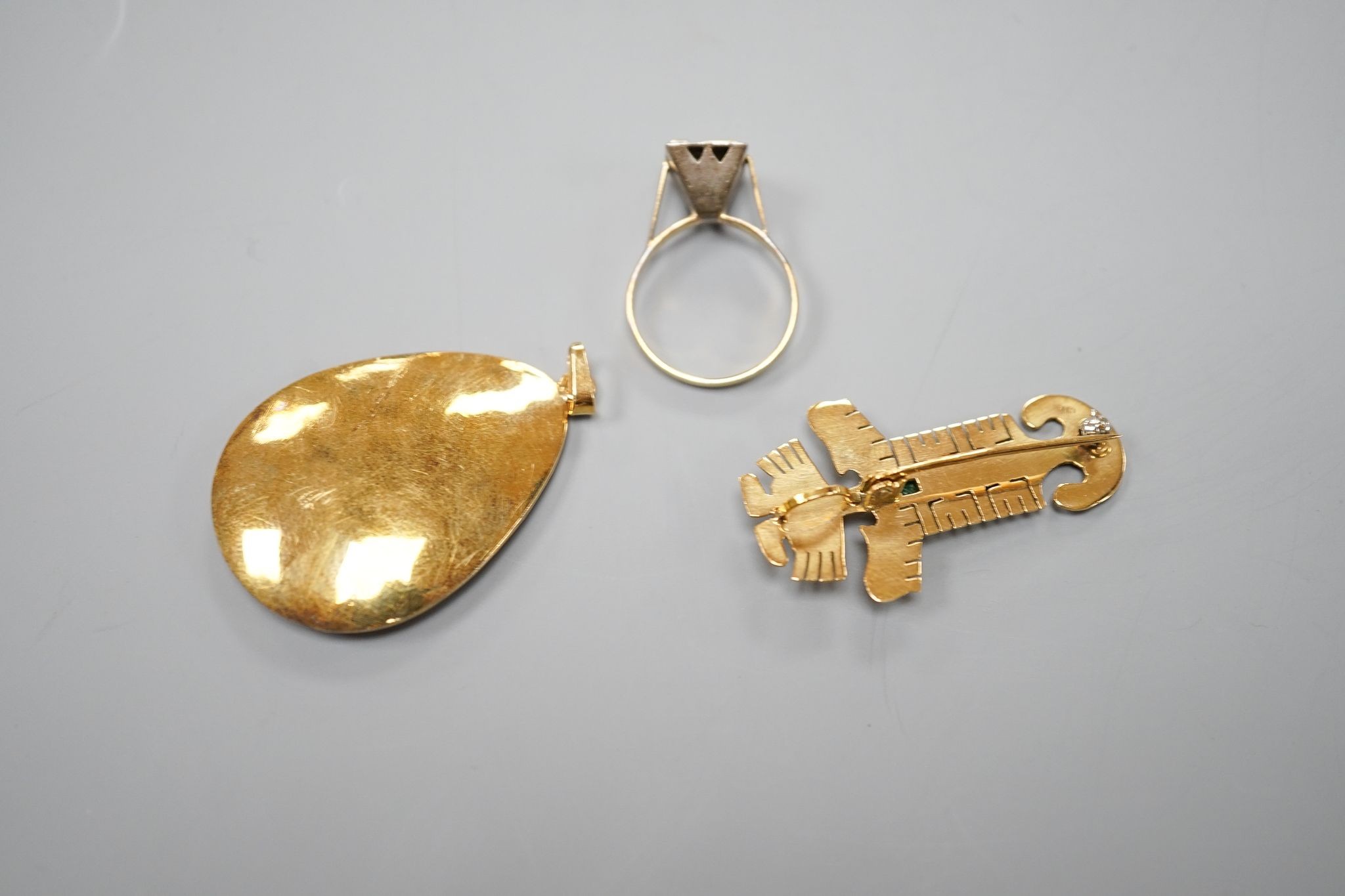 A South American 18k yellow metal and emerald set pendant, 39mm, a similar gem set brooch and ring